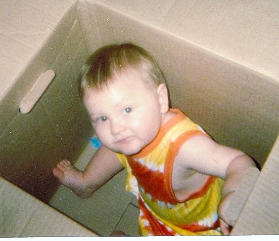 Photo of a young boy in a cardboard box